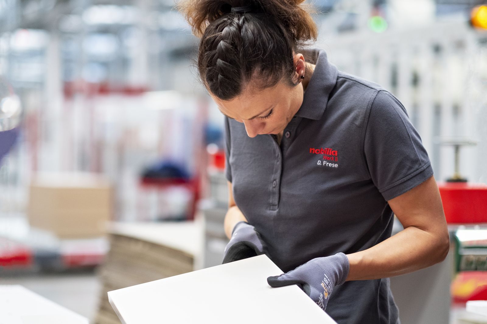 nobilia employee inspecting a cabinet component in the German factory